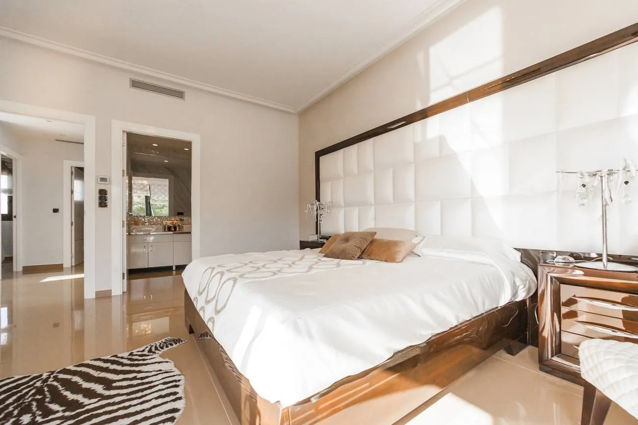 Chambre blanche baignée de lumière avec parquet clair