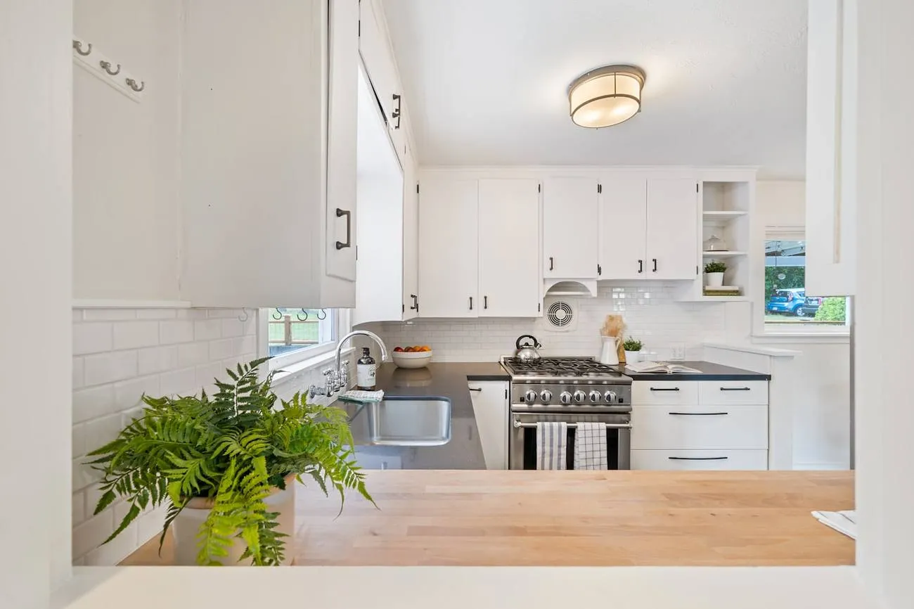Cuisine claire équipée avec plan de travail en bois