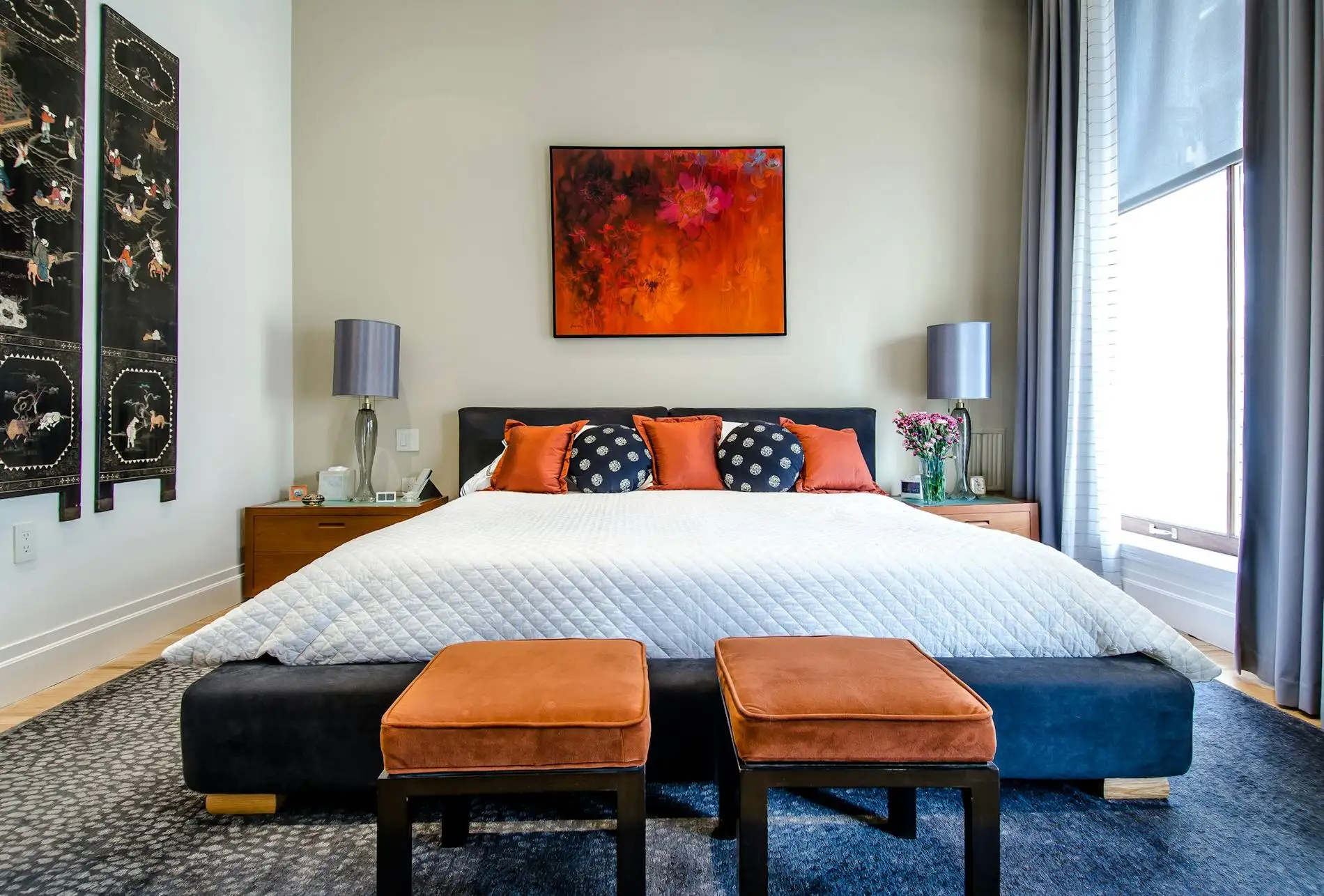 Chambre d’hôtel à la lumière tamisée, bout de lit et fenêtre habillée