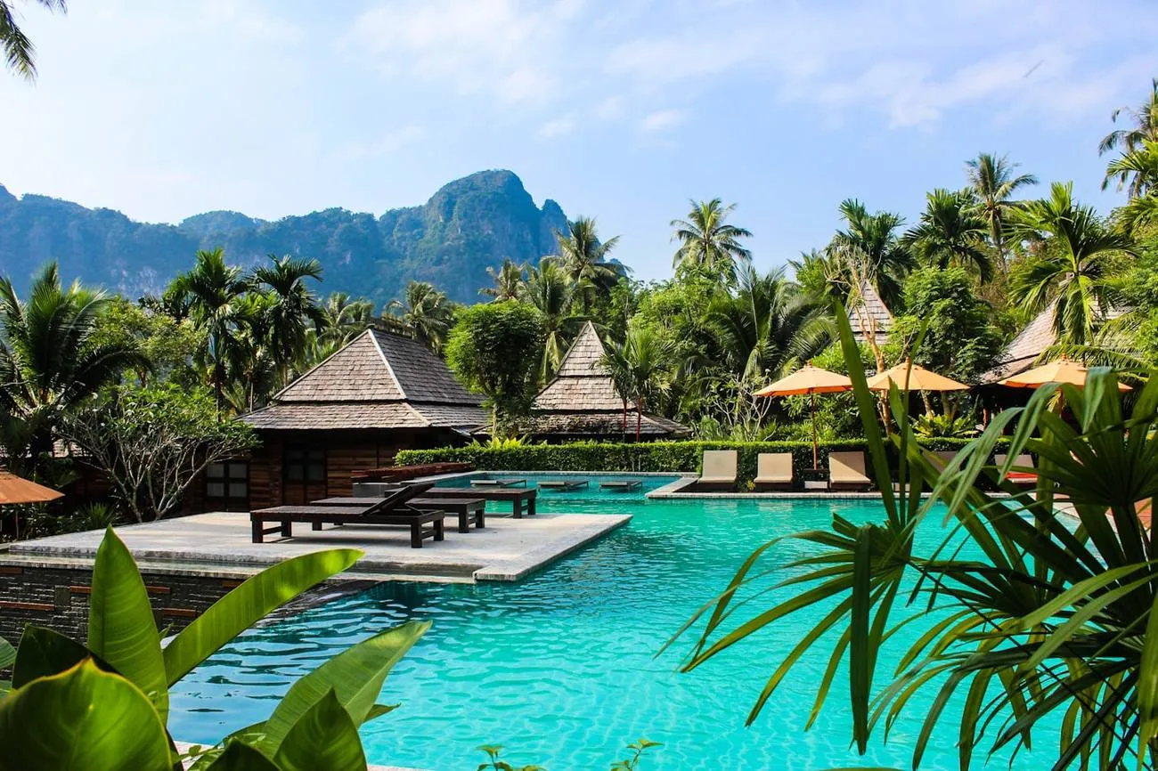 Piscine bordée de palmiers dans un jardin tropical